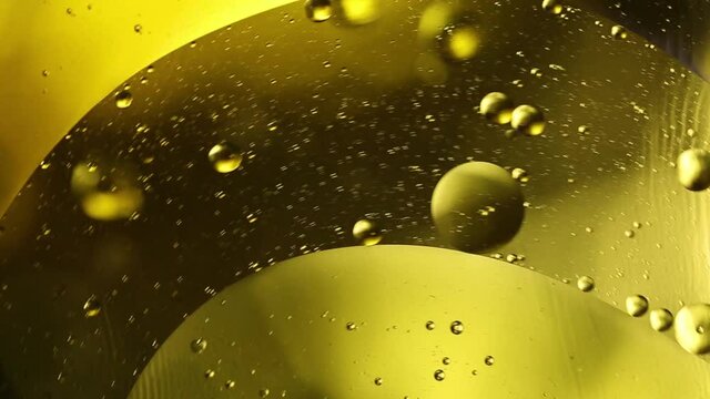 Bright yellow moving circles liquid bubbles. Olive oil, beer, drink close-up macro photography.