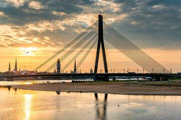 Fototapeta na wymiar View on cable bridge and historical district of o Riga - the capital of Latvia and famous Baltic city widely known among tourists due to its unique medieval and Gothic architecture