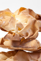 
Freshly baked baskets of filo dough on a white plate. The basis for the dessert. Thin Balkan dough