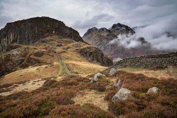 Epic Winter landscape image of view from Side Pike towards Langdale pikes with low level clouds on...