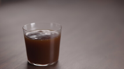 coffee pour into tumbler glass on walnut table