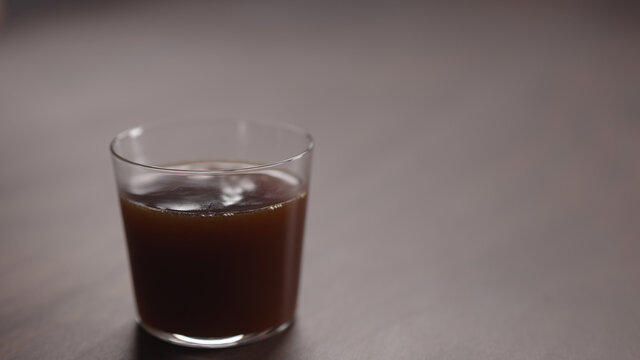coffee pour into tumbler glass on walnut table