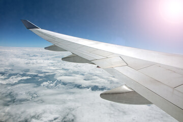 Wing of an airplane flying above the clouds. look at the sky from the window of the plane