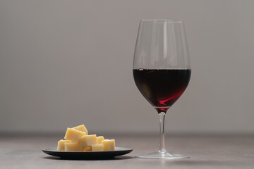 glass of red wine with vintage cheese on small plate