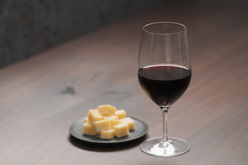 glass of red wine with vintage cheese on small plate