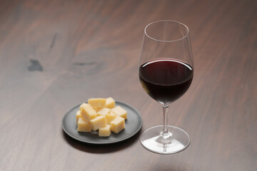 glass of red wine with vintage cheese on small plate