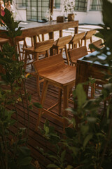 Handcrafted wooden chair on a wooden floor and decorated with plants.