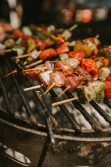 shrimp and vegetable skewers on a black grill.