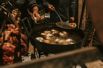 Fototapeta premium chef frying Argentinean food with beef in the background.