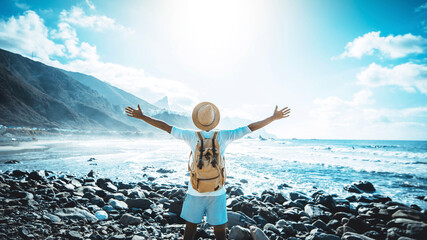 Happy man with arms up enjoying freedom on the beach - Hiker with backpack celebrating success outdoor - Blue filter