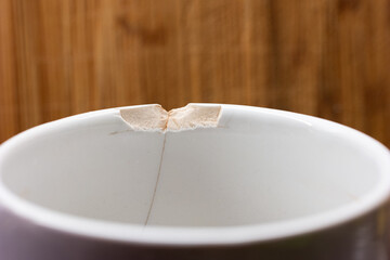 Chipped ceramic cup macro close up shot in the kitchen