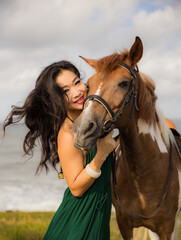 Fototapeta premium Portrait of happy smiling woman and brown horse. Asian woman hugging horse. Romantic concept. Human and animals relationship. Nature concept. Bali