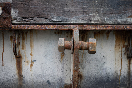 detail of a rusty screw of a metal structure. The screw is loose