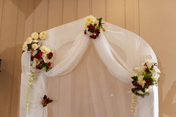 decorations with flowers at the wedding, the interior of the restaurant is prepared by the decorator for the holiday, beautiful fresh flowers in vases on the table, a bouquet as a gift from the guests