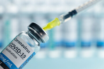 Vaccine vial dose coronavirus or covid 19 shot drug needle syringe on blue background. Medical concept vaccination hypodermic injection treatment disease prevention immunization illness.