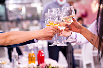 hands with a glass of wine. toast at the party. alcohol consumption. Holiday. Sommelier. - obrazy, fototapety, plakaty
