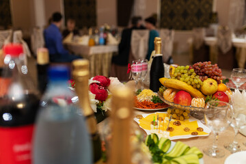 decorations with flowers at the wedding, the interior of the restaurant is prepared by the decorator for the holiday, beautiful fresh flowers in vases on the table, a bouquet as a gift from the guests