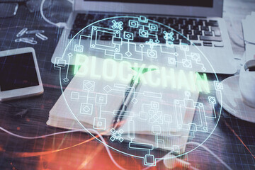 Double exposure of blockchain theme drawings and desk with open notebook background. Concept of Crypto currency