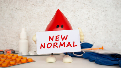 A toy drop of blood holds a white paper card with the inscription NEW NORMAL.