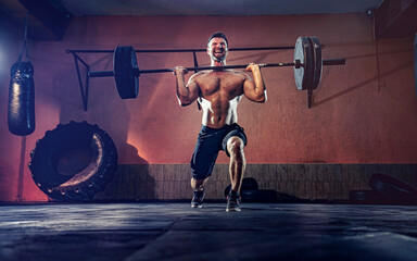 Muscular fitness man doing barbell lunges in his garage, selfisolation. Functional training. Snatch...