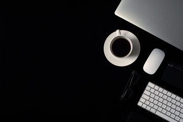 Desk office with laptop, mouse, keyboard, notepad, coffee cup, smartphone and glases. Flatlay with copy space.