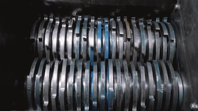 Rotation of gears for crushing debris. Steel cutters. raw material processing machine