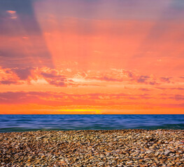 Obraz premium stony sea coast at the dramatic red sunset, natural marine background