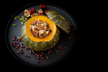Steamed sticky rice, red bean, date and nuts inside pumpkin