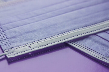 protective medical masks of purple color close-up on purple background
