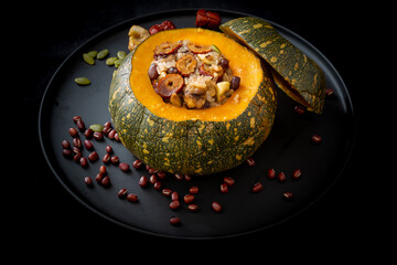 Steamed sticky rice, red bean, date and nuts inside pumpkin