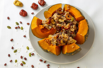 Steamed sticky rice, red bean, date and nuts inside pumpkin