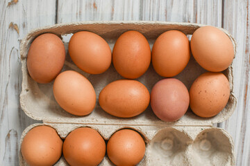 Fresh chicken eggs in a cardboard box or tray made from natural materials. Organic farm product concept.