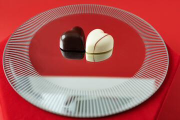 Chocolates with mirror reflection on red background