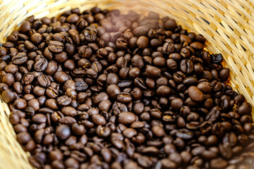 Coffee bean in the bamboo basket with a little bit smoke after roasting process. Photo with some part blurred.
