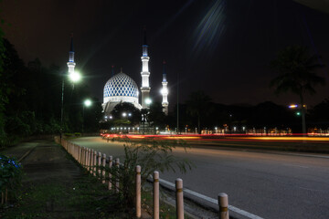 Fototapeta na wymiar Side road view of shah alam or blue mosque with trail lights. 