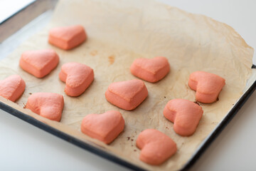 homemade pink shortbread cookies for valentine's day on a baking sheet.