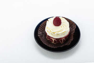 Cake basket with cream and raspberries, on paper on a light background