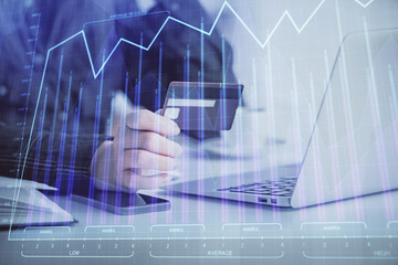 Multi exposure of woman on-line shopping holding a credit card and financial graph drawing. Stock market E-commerce concept.