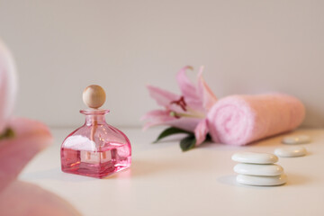 Rose essential oil, towel and lily flower