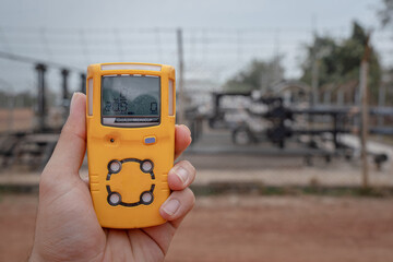 Action of a worker is using a portable gas detector device to testing the gas condition before...