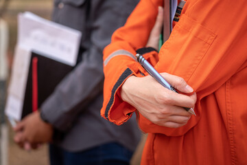 Action of safety officer or supervisor 's hand is holding on elbow during group meeting with other staffs. Industrial people  in action, close-up photo.