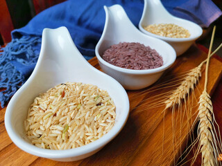 Brown rice and Riceberry on Natural wood in the background