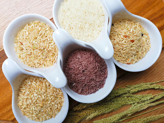 Jasmine rice, Brown rice, Red rice,Black rice, Mixed rice and Jasmine rice, Brown rice, Red rice,Black rice, Mixed rice and Riceberry on Natural wood in the background,Top view,Vertical