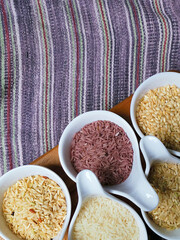 Jasmine rice, Brown rice, Red rice,Black rice, Mixed rice and Riceberry on Natural fabric in the background,Top view,Vertical
