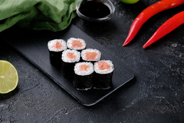Sushi rolls with salmon on a black background