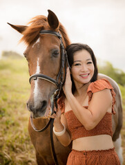 Portrait of smiling woman and brown horse. Asian woman hugging horse. Romantic concept. Positive emotions. Love to animals. Nature concept. Bali