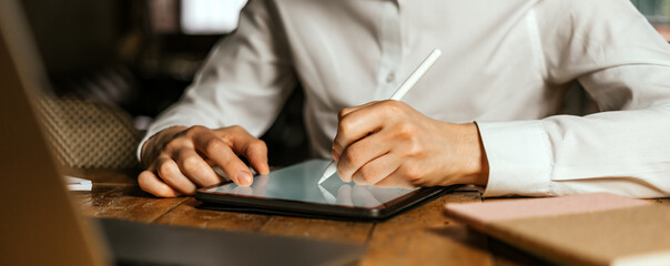 Male hands drawing on digital tablet with electronic pen. Freelancer designer working remotely....