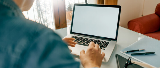 Close up of male hands and laptop with white blank screen. Mock-up