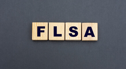 concept acronym FLSA on wooden cubes on a gray background