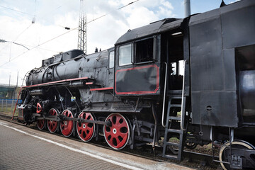 Fototapeta na wymiar The locomotive of the last century standing under steam
